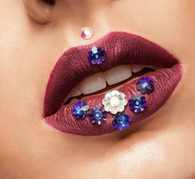 Close up of beautiful womna with mate creative lipstick and diamond flowers upper lip piercing